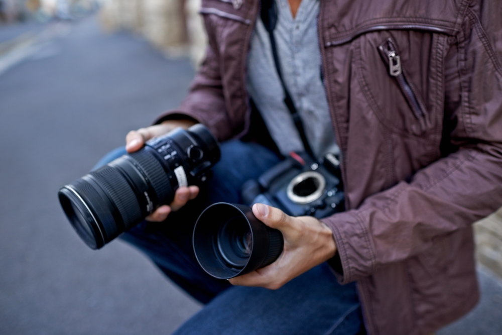Photographer holding two lenses