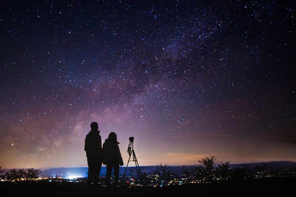 Silhouettes of people observing stars